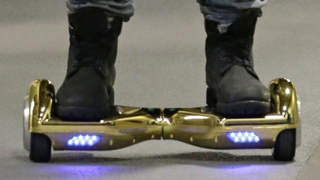 FILE - In this Oct. 5, 2015 file photo, Seattle Seahawks wide receiver B.J. Daniels rides through a hallway at CenturyLink Field on an electric self-balancing scooter commonly called a "hoverboard," as he arrives for an NFL football game against the Detroit Lions in Seattle. Since December 2015, several universities have banned or limited hoverboards on their campuses, saying the two-wheeled, motorized scooters are unsafe. Beyond the risk of falls and collisions, colleges are citing warnings from federal authorities that some of the self-balancing gadgets have caught on fire. (AP Photo/Elaine Thompson, File)