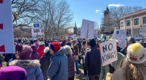 Protesters extended across Centre Street and Beacon Street, with hundreds of signs criticizing the president and his administration. (Nathan Yarnall / Heights Editor)